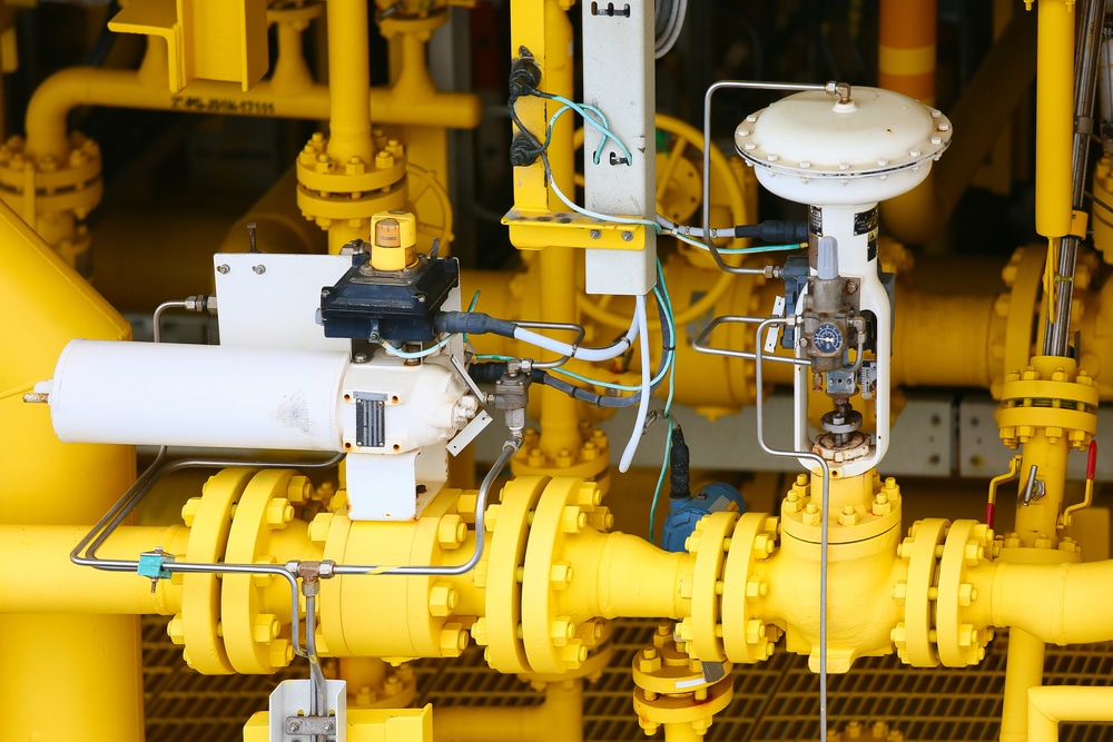 The image shows a detailed view of industrial equipment, specifically focusing on yellow piping and control valves. Key components include various types of valves, actuators, and associated instrumentation, all part of a process control system likely used in an oil refinery, chemical plant, or gas processing facility. The equipment is predominantly painted yellow, with several visible connections and pipelines, indicating a complex network for fluid or gas control.